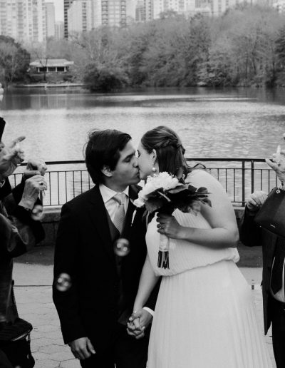 Bride and Groom kissing with in font of Piedmont Park Lake